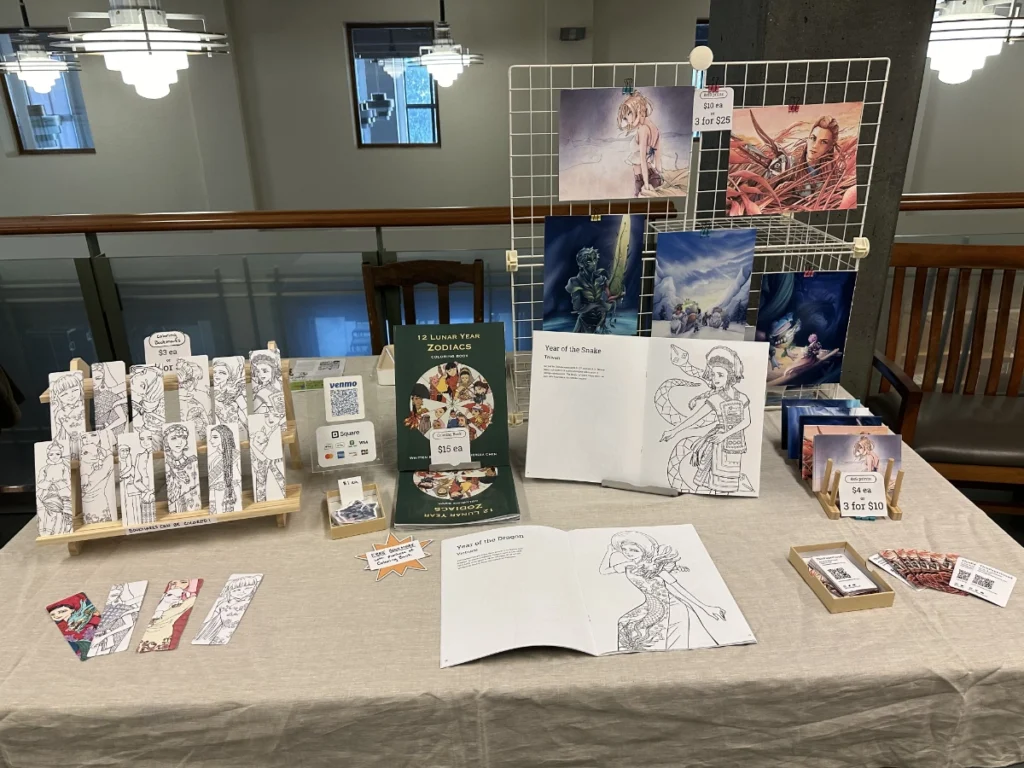 A table of Theresa Arzola's work under the brand This Paper Cloud, showcasing a coloring book, prints, and colorable bookmarks