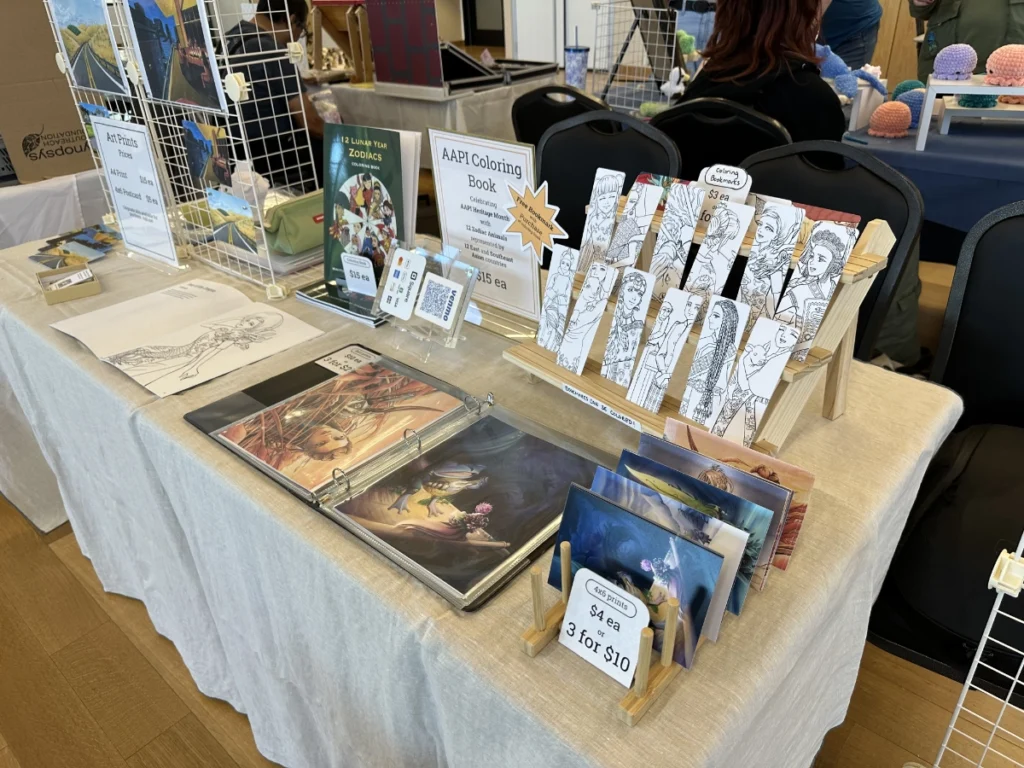 A table of Theresa Arzola's work under the brand This Paper Cloud, showcasing a coloring book, prints, and colorable bookmarks